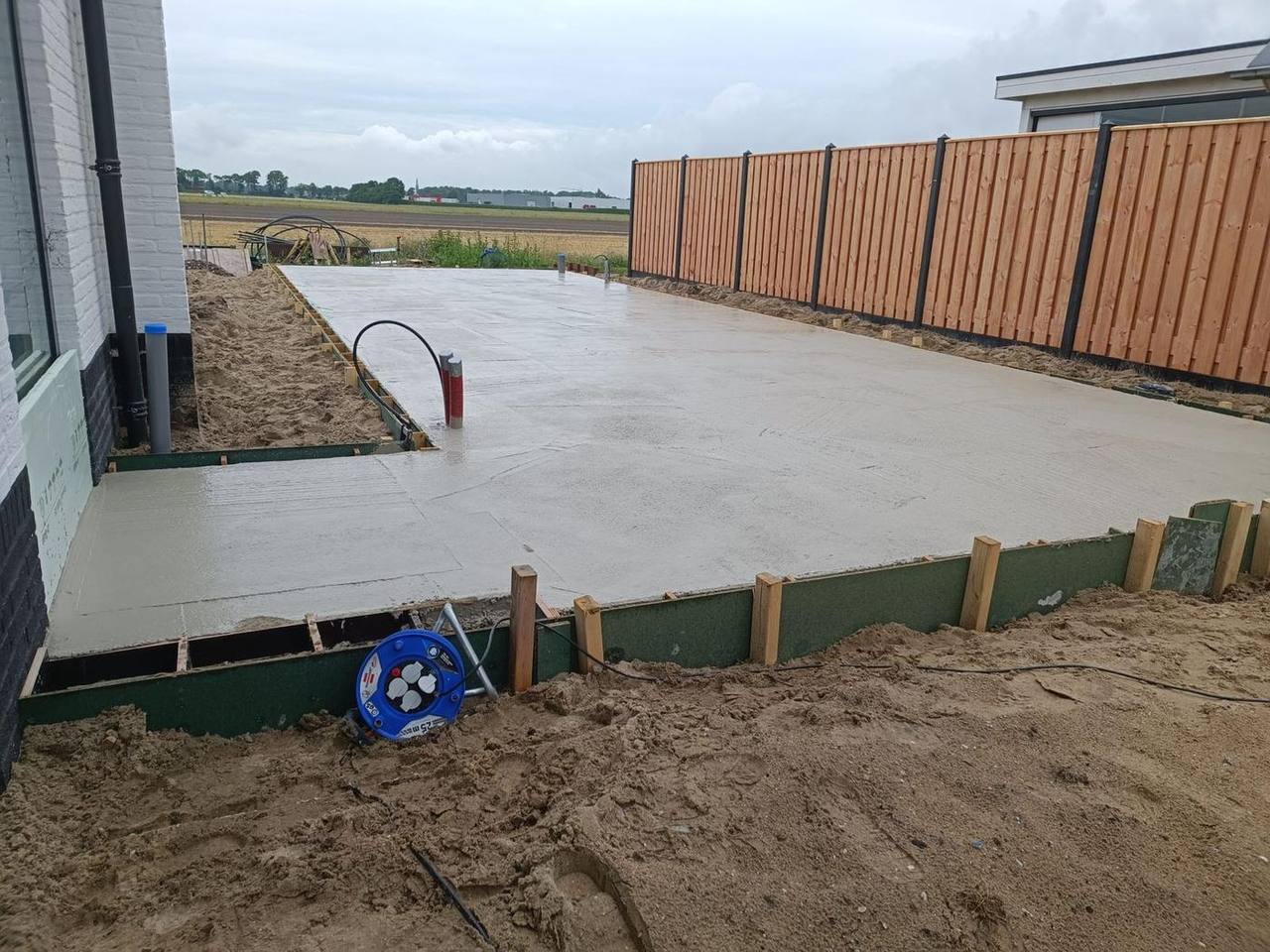 Gestorte betonplaat langs de schutting