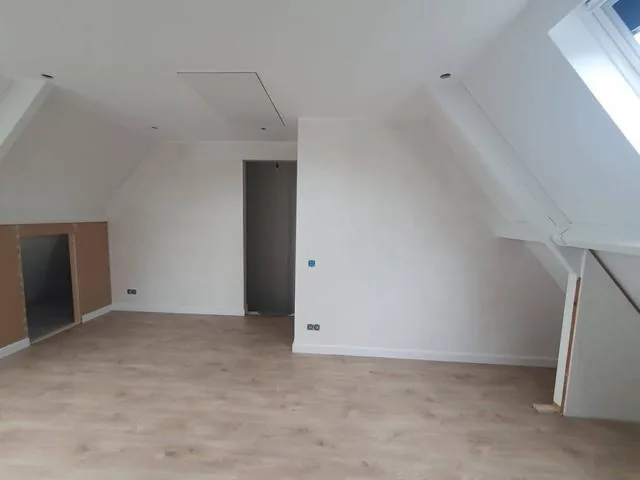 Afgewerkte zolder met knieschotten en dakraam