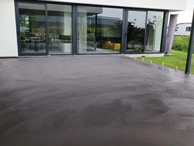 Strakke betonvloer onder een overkapping