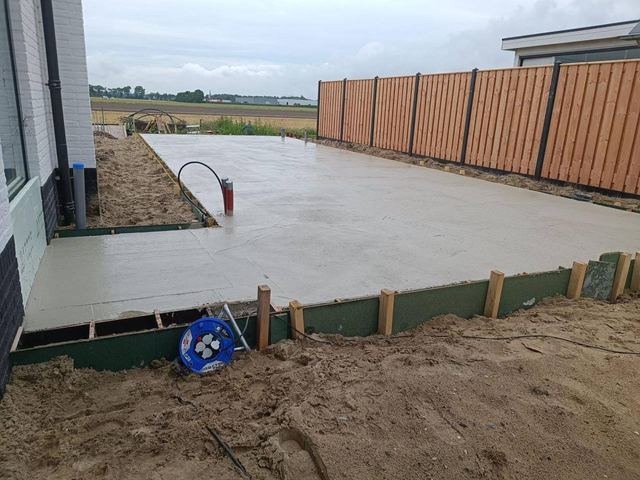 Gestorte betonplaat langs de schutting