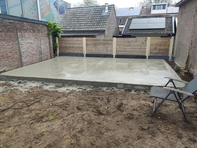 Gestorte funderingsplaat tegen de schutting