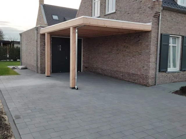 Carport tegen de woning, met nieuwe bestrating