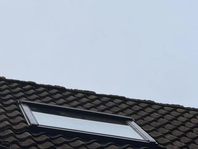 Het dakraam van buiten, netjes in de pannen